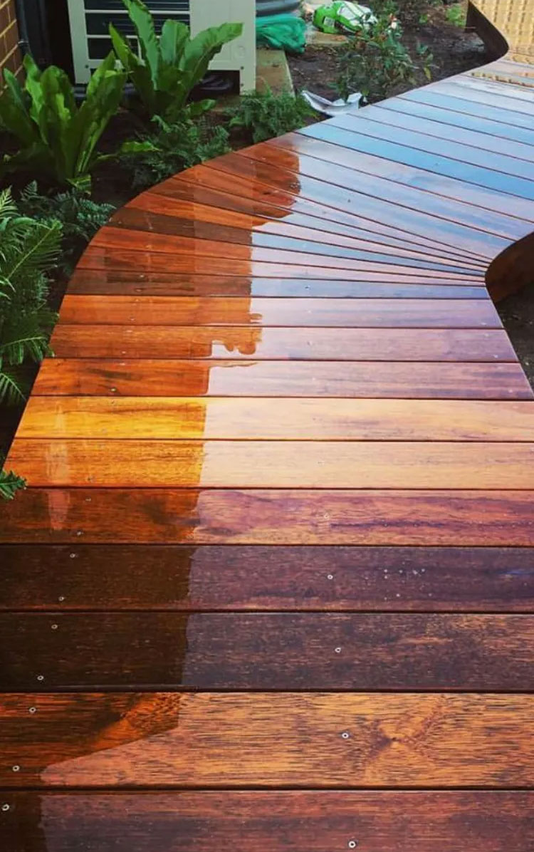 Freshly re-stained curved wood deck walkway with the stain still wet